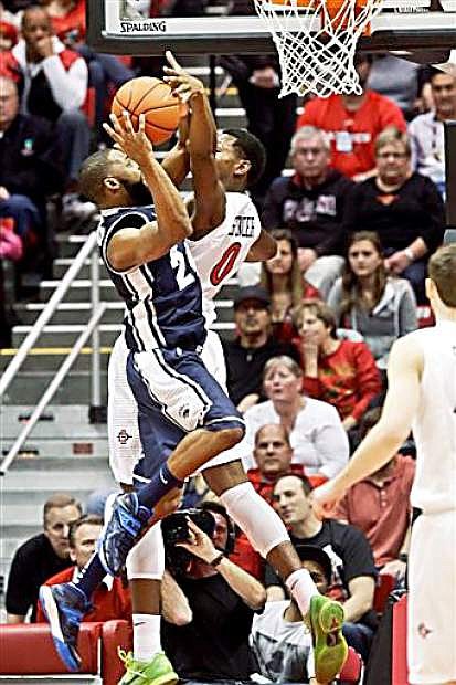 Nevada guard Deonte Burton, front, scores despite the defensive effort of San Diego State&#039;s Skylar Spencer during the first half of an NCAA college basketball game Saturday, Feb. 8, 2014, in San Diego. (AP Photo/Lenny Ignelzi)