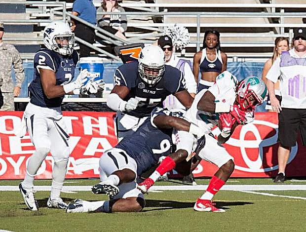 Nevada defenders (left to right) Asauni Rufus, Rykeem Yates and Lenny Jones bring down a New Mexico runner in the Wolf Pack&#039;s 35-17 win over New Mexico on Saturday, Oct. 10, at Mackay Stadium.