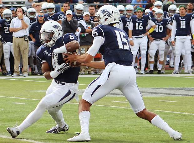 Tyer Stewart hands the ball off to Don Jackson in Nevada&#039;s game against Hawaii.