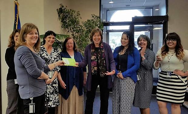 On behalf of the Nevada Division of Welfare and Supportive Services, Miki Allard, staff specialist, presents a $1,500 check to Kathy Bartosz, director of Partnership Carson City.
