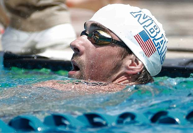 Michael Phelps looks at the scoreboard after the 100-meter butterfly during the Arena Grand Prix swim meet, Thursday, April 24, 2014, in Mesa, Ariz. It is Phelps&#039; first competitive event after a nearly two-year retirement. (AP Photo/Matt York)