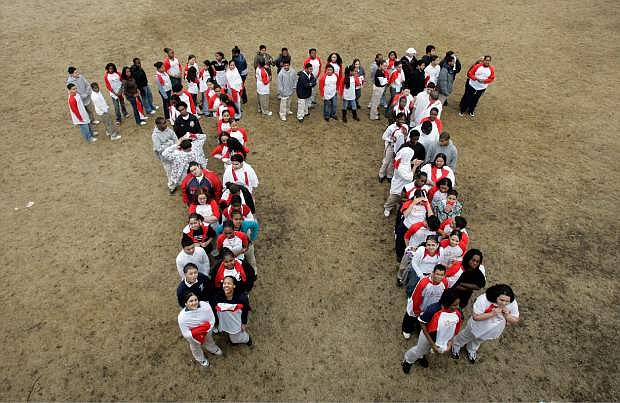 FILE - In this March 13, 2007 file photo, students from the Maurice J. Tobin School makes a human Pi symbol at the school in Boston during a celebration of Pi Day. Saturday is the day when love of math and a hankering for pastry come full circle. Saturday is Pi day, a once-in-a-year calendar date that this time squares the fun with a once-in-a-century twist. Saturday is 3-14-15, the first five digits of the mathematical constant Pi: 3.141592653. So the best time to celebrate is at 9:26 and 53 seconds. The next time that happens is in March 2115.  (AP Photo/Chitose Suzuki, File)