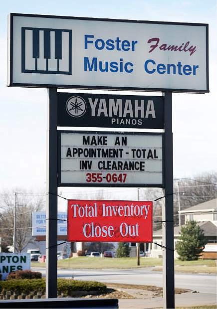 In this Dec. 3, 2014, photo, the Foster Family Music Center piano store sign alerts passing traffic of the store&#039;s closing, in Bettendorf, Iowa. The number of stores dedicated to selling pianos is dwindling across the country as fewer people take up the instrument and those who do opt for a used piano or a less expensive electronic keyboard. (AP Photo/Charlie Neibergall)
