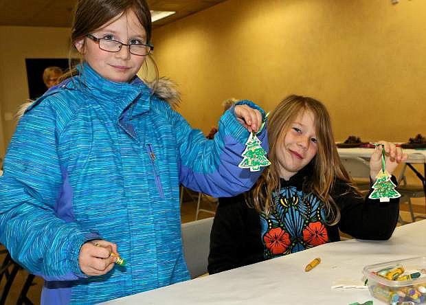 8-year-olds Sophia Whatley and Ashley Waiksoras display their Christmas tree ornaments they worked on at the &#039;Pines Are Fine&#039; event at the Nevada State Museum Saturday.