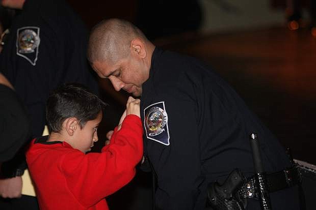 Eight-year-old Matthew pins his father, Jose Campos&#039; badge during the pinning ceremony of the Nevada Department of Public Safety Basic Academy No. 68 graduation on Thursday at the Carson City Community Center.