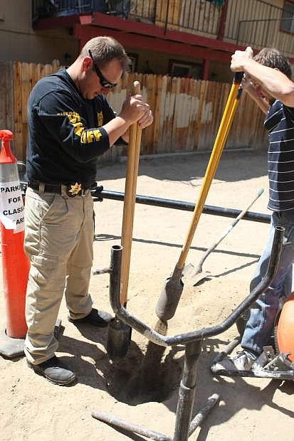 Bret Willey of the Tri-County Gang Unit and Brad Spriggs of Millard Realty work at Stanton Arms Apartments on Saturday morning. The gang unit installed basketball hoops, tetherball games and monkey bars at the apartment complex.