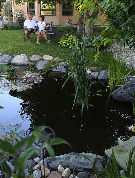Paul and Sheryl Seaman relax by their backyard pond that will be featured on the pond tour.