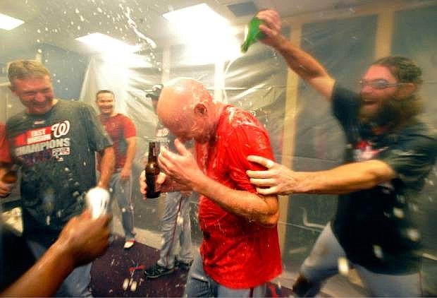 FILE - In this Sept. 16, 2014 file photo, Washington Nationals manager Matt Williams, center, is doused with champagne by Jayson Werth, right, as they celebrate their NL East division win after a baseball game against the Atlanta Braves in Atlanta. Williams was in his 18th game as a major league manager, still learning on the job with the Washington Nationals, when he went with his gut. Williams saw Bryce Harper hit a comebacker, jog out of the batter&#039;s box and veer off toward the dugout several strides before reaching first base. Williams, seething, yanked Harper from the lineup. That decision in April was one of thousands on the way to an NL East title as a rookie skipper that made clear, if there were any doubts, the 48-year-old Williams would do things his way.  (AP Photo/David Tulis, File)