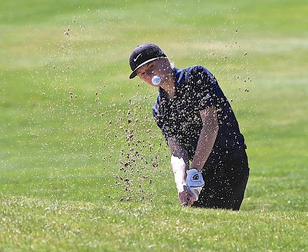 Sophomore Ethan Lepire chips out of a bunker on the first hole Wednesday at Genoa Lakes Golf Course.