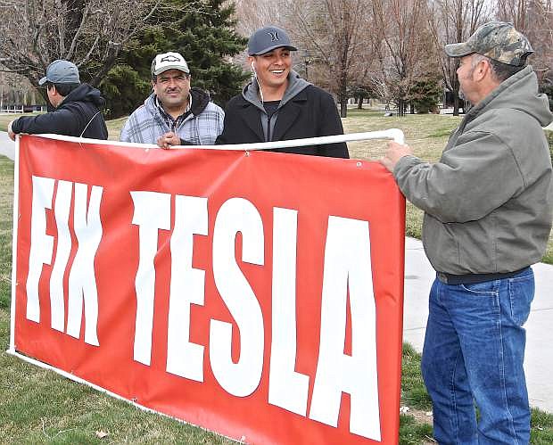 A group of protestors hold a &#039;Fix Tesla&#039; sign in front of the Legislative Building in downtown Carson City Friday.