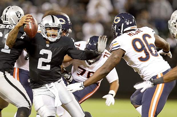 Oakland Raiders quarterback Terrelle Pryor (2) avoids Chicago Bears defensive end Kyle Moore (96) on his 25-yard touchdown run during the third quarter of an NFL preseason football game in Oakland, Calif., Friday, Aug. 23, 2013. (AP Photo/Marcio Jose Sanchez)