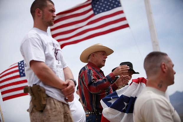 FILE - In this April 18, 2014 file photo, rancher Cliven Bundy, flanked by armed supporters, speaks at a protest camp near Bunkerville, Nev. The victory Bundy claimed in a government standoff with armed militiamen has served to embolden right-wing extremists and conspiracy theorists across the country, the Southern Poverty Law Center said in a new report Thursday, July 10, 2014. (AP Photo/Las Vegas Review-Journal, John Locher, File) LOCAL TELEVISION OUT; LOCAL INTERNET OUT; LAS VEGAS SUN OUT