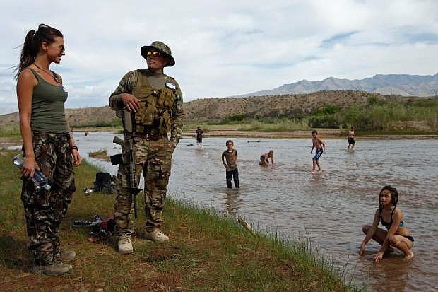 Jennifer Scalzo, left, and her husband Anthony Scalzo stand by the Virgin River during a rally in support of Cliven Bundy near Bunkerville, Nev. Friday, April 18, 2014. (AP Photo/Las Vegas Review-Journal, John Locher)