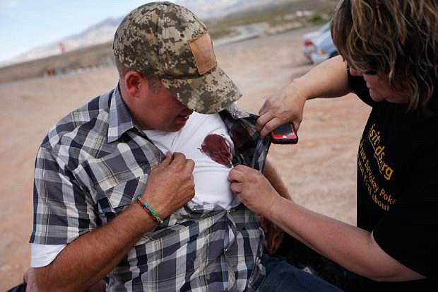 Krissy Thornton, right, looks at blood from a taser wound on Ammon Bundy near Bunkerville, Nev. Wednesday, April 9, 2014. Bundy was tasered by Bureau of Land Management law enforcement officers while protesting the roundup of what the BLM calls &quot;trespass cattle&quot; that rancher Cliven Bundy grazes in the Gold Butte area 80 miles northeast of Las Vegas. (AP Photo/Las Vegas Review-Journal, John Locher)
