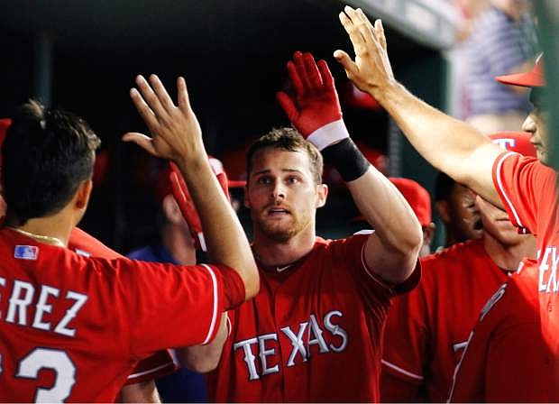 Texas Rangers&#039; Craig Gentry celebrates after scoring on an Ian Kinsler single against the Tampa Bay Rays during the third inning of an American League wild-card tiebreaker baseball game Monday, Sept. 30, 2013, in Arlington, Texas. (AP Photo/Tim Sharp)