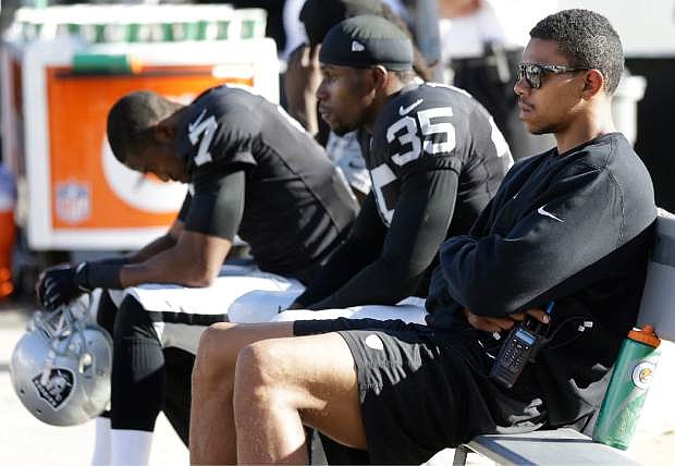 Oakland Raiders quarterback Terrelle Pryor, right, defensive back Chimdi Chekwa (35), and punter Marquette King (7) sit on the bench during the fourth quarter of the Raiders&#039; 24-14 loss to the Washington Redskins in an NFL football game Sunday, Sept. 29, 2013, in Oakland, Calif. (AP Photo/Marcio Jose Sanchez)