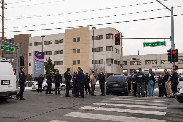 Officers gather in front of the Renown Regional Medical Center  after a lone gunman shot and injured four people before killing himself , Tuesday, Dec. 17, 2013 in Reno, Nev. (AP Photo/Scott Sady)