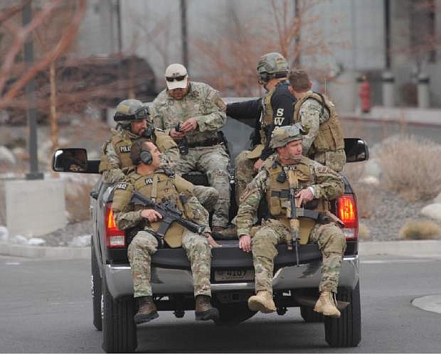 SWAT team members are trucked from near the Renown helicopter pad to the Renown Medical Center where a lone gunman shot and injured four people before killing himself at a sprawling medical campus Tuesday, Dec. 17, 2013 in Reno, Nev. (AP Photo/The Reno Gazette-Journal, Tim Dunn)  NO SALES; NEVADA APPEAL OUT; SOUTH RENO WEEKLY OUT