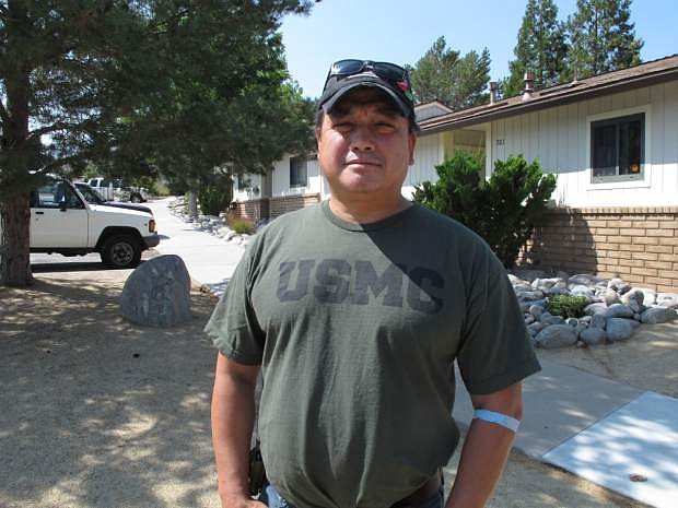 Joaquin Roces, 49, poses for a photograph on Sept. 1, 2015,  in front of his home on the north edge of Reno, Nev.,  where he&#039;s threatened with eviction after losing his job of 5 years with the Reno Housing Authority. The disabled U.S. military veteran has filed a lawsuit in U.S. District Court in Reno accusing the authority of violating federal labor laws and firing him in retaliation for complaining about unpaid wages. (AP Photo/Scott Sonner)