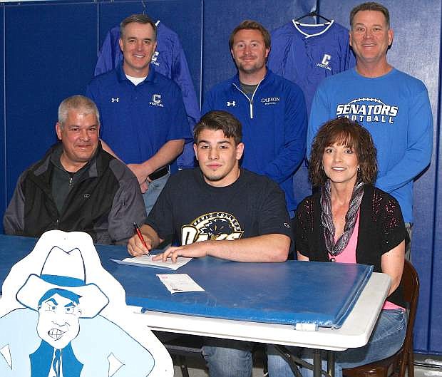 Brady Rivera, seated center, signs his letter of intent to wrestle for Menlo College in Atherton, Ca. Thursday at Carson High. Also pictured are Tim McCarthy, Paul Carter and Blair Roman, seated are Brady&#039;s parents, Reagan and Dawn Rivera.