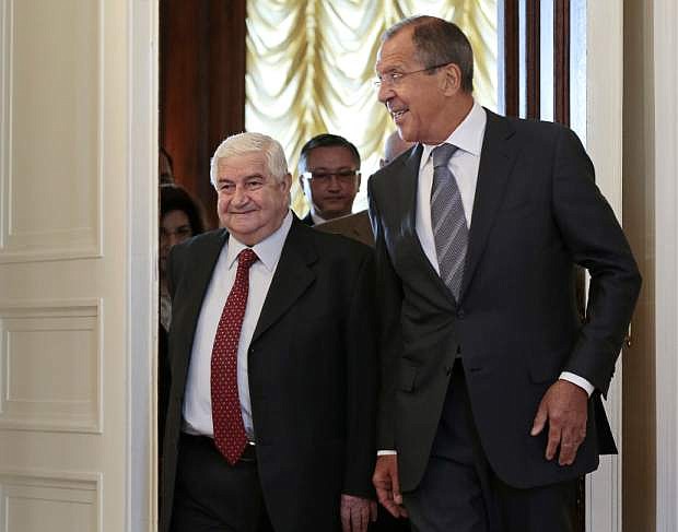 Russian Foreign Minister Sergey Lavrov welcomes his Syrian counterpart Walid al-Moallem, left, prior to talks in Moscow on Monday, Sept. 9, 2013. (AP Photo/Ivan Sekretarev)