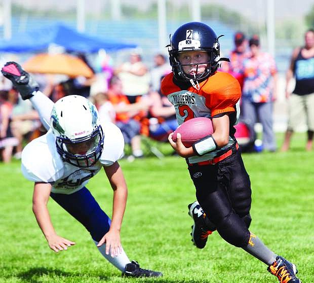 Gabe Tollestrup, 9, of the Fernley Vaqueros shrugs off a Damonte tackler on Saturday at CHS.