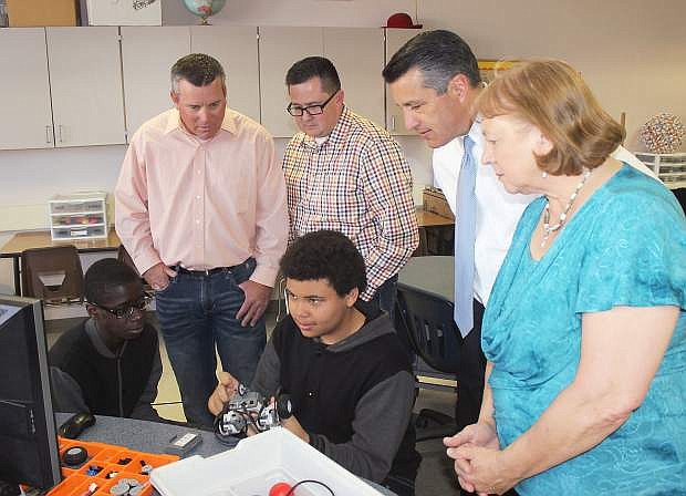 Churchill County Middle School students Angelo Van, left, and Patrick Morales (both seated) work on their STEM project. Looking on, from left, are Churchill County School District trustee Matt Hyde, trustee Greg Koenig, Gov. Brian Sandoval and Superintendent Sandra Sheldon.