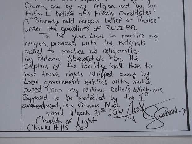 This May 9, 2014, photo,shows the closing of a hand-written lawsuit filed by Alex C. Nelson, a Nevada inmate who practices Satanism and accuses the Washoe County jail of violating his right to freely exercise his religion. Nelson, 33, said in the amended complaint filed in U.S. District Court in Reno on Wednesday that he&#039;s been denied meals that adhere to his religious diet. (AP Photo/Scott Sonner).