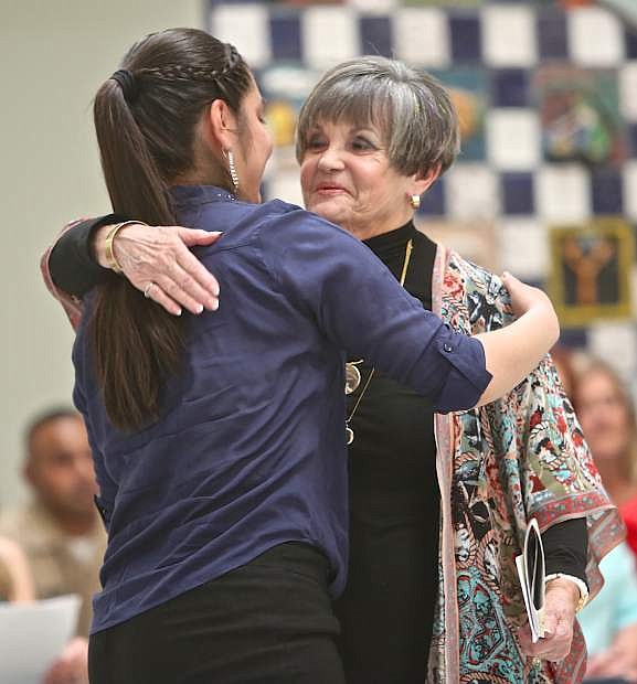 Fabiola Mata-Garcia gets a hug from Mary Lee Castro-Wilson of the American Association of University Women after receiving her scholarship on May 19 at Carson High School.