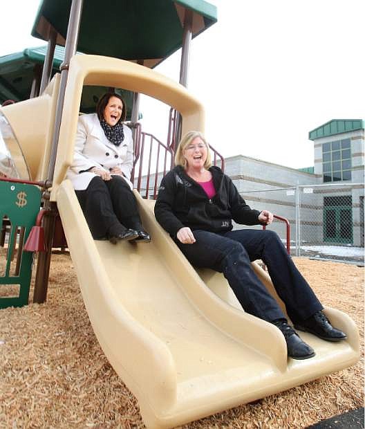 Mark Twain Elementary school principal Ruthlee Caloiaro, left, and kindergarten teacher Debi Crozier try out the new playground equipment installed for the kindergartners.