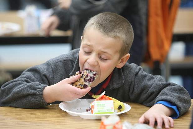 Fremont Elementary School second-grader Nathan Stoffer eats his blueberry muffin on Thursday morning. Lunch also included a banana, milk, string cheese and apple or orange juice.