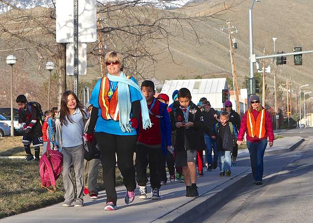 Literary Implementation Specialist Pam Cowperthwaite leads Fremont students across Little Lane Wednesday morning in observance of Nevada Moves Day .