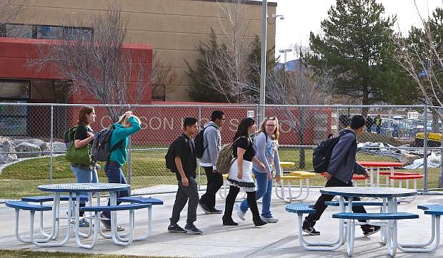 Students walk past a construction fence at CHS on Friday. A &#039;secure envelope&#039; is being created around the school.