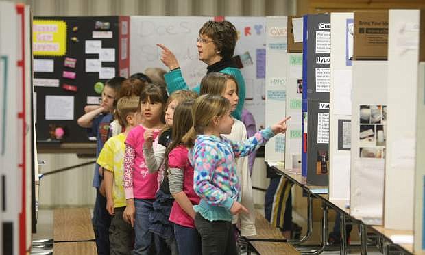 Karen Hellman and her first-grade class at Fritsch Elementary School look at science fair projects on Thursday afternoon.