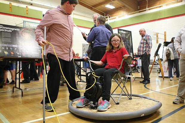 Thirteen-year-old Joey Chappuis, a seventh grader at Eagle Valley Middle School, gives 8-year-old Ava Schirlls a ride on the hover craft that he built.