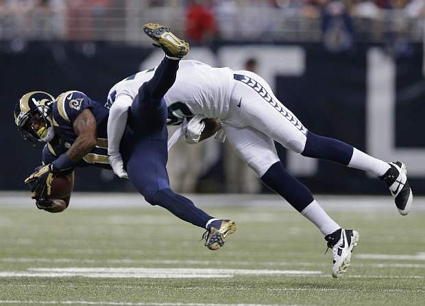 St. Louis Rams wide receiver Tavon Austin (11) gets tackled by Seattle Seahawks defensive end Cliff Avril (56) during the first half of an NFL football game, Monday, Oct. 28, 2013, in St. Louis. (AP Photo/Michael Conroy)