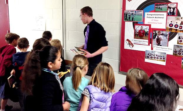 Honors student Tyler Warren hands out books to students as a part of his senior project.