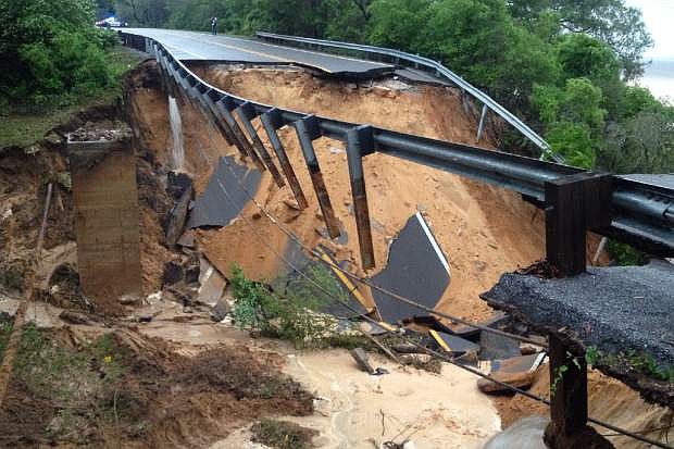 A portion of the Scenic Highway collapsed near Pensacola, Fla., Wednesday April 30, 2014. Heavy rains and flooding have left people stranded in houses and cars in the Florida Panhandle and along the Alabama coast. According to the National Weather Service, an estimated 15-20 inches of rain has fallen in Pensacola in the past 24 hours. (AP Photo/Pensacola News Journal, Katie E. King)