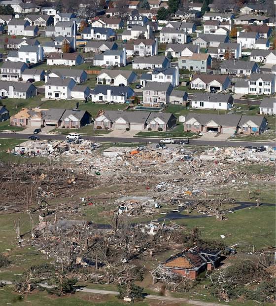 This aerial view on Monday, Nov. 18, 2013, shows untouched homes and homes destroyed by a tornado that hit the western Illinois town of Washington on Sunday. It was one of the worst-hit areas after intense storms and tornadoes swept through Illinois. The National Weather Service says the tornado that hit Washington had a preliminary rating of EF-4, meaning wind speeds of 170 mph to 190 mph. (AP Photo/Charles Rex Arbogast)