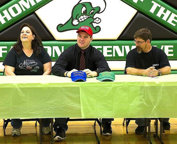 Fallon senior Cody Stadtman, middle, is flanked by his parents Carolyn, right, and Rick Grady after signing his National Letter of Intent with Malone University on Wednesday to play football.