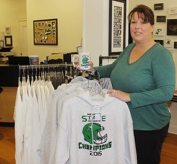 Kelly Campbell, a small business owner in downtown Fallon, displays state championship football hooded  sweatshirts available at Buttsup Duck Design.