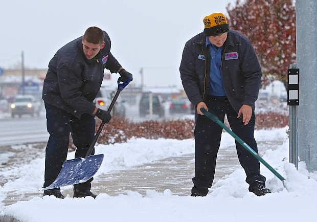 Michael Hohl Subaru employees Brandon Mullens and Dalton Wells, both of Carson City, clear the sidewalk in front of the dealership Wednesday afternoon.