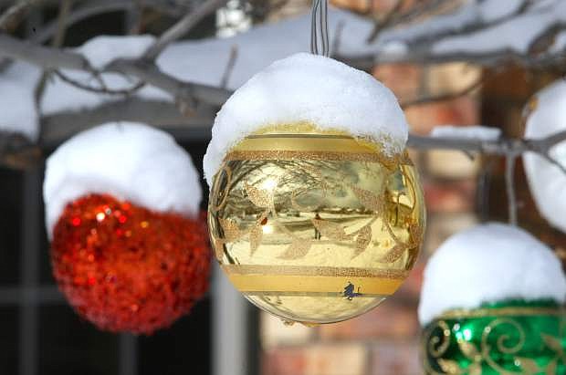 Outdoor holiday ornaments are decorated with fresh snow on Monday morning.