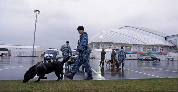Security personnel walk with their dogs outside Fisht Olympic Stadium at the 2014 Winter Olympics Monday, Jan. 27, 2014, in Sochi, Russia. The Olympics begin Feb. 7th. (AP Photo/David J. Phillip)