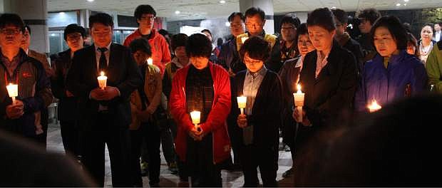 Parents attend a candle light vigil to hope for their children&#039;s safe return at Danwon high school in Ansan, South Korea, Wednesday, April 16, 2014. A South Korean passenger ship carrying more than 470 people, including many high school students, sunk off the country&#039;s southern coast Wednesday after sending a distress call, officials said. (AP Photo/Yonhap) KOREA OUT