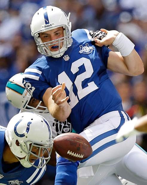 Indianapolis Colts&#039; Andrew Luck (12) fumbles the ball as he is sacked by Miami Dolphins&#039; Derrick Shelby during the first half an NFL football game on Sunday, Sept. 15, 2013, in Indianapolis. The Colts recovered the ball. (AP Photo/Michael Conroy)