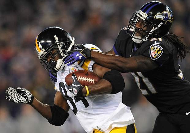 Pittsburgh Steelers wide receiver Antonio Brown, left, is tackled by Baltimore Ravens cornerback Lardarius Webb after getting a first down in the first half of an NFL football game on Thursday, Nov. 28, 2013, in Baltimore. (AP Photo/Gail Burton)