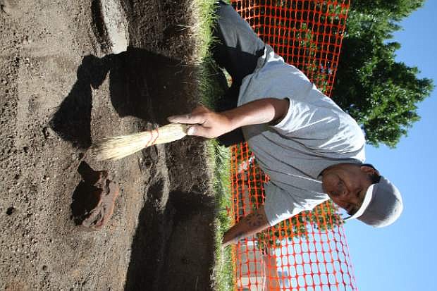 UNR student Lonnie Teeman clears sand away from a brick during an archaeological dig at Stewart Indian School.