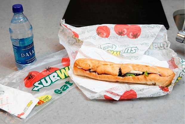 FILE - This Aug. 11, 2009, file photo, shows a chicken breast sandwich and water from Subway on a kitchen counter in New York. Subway says an ingredient dubbed the &quot;yoga mat&quot; chemical will be entirely phased out of its bread by the week of April 14, 2014. The disclosure comes as Subway has suffered from an onslaught of bad publicity since a food blogger petitioned the chain to remove the ingredient. (AP Photo/Seth Wenig, File)