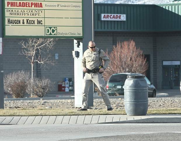 A Douglas County Sheriff&#039;s officer inspects a suspicious container at the corner of Tillman and Kimmerling in the Gardnerville Ranchos Saturday morning. The contents turned out to be horse feed.